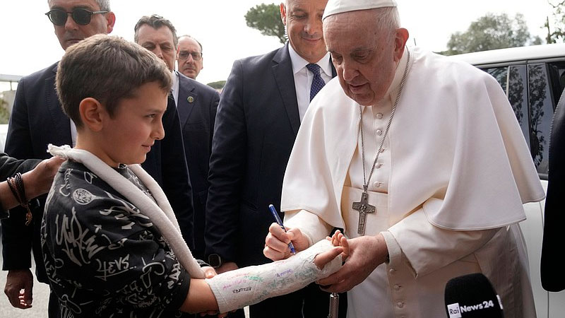 Papa Francisco firmando la escayola de un Niño al dejar el Hospital