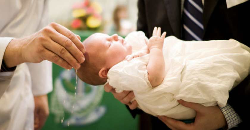 bebe dormido siendo bautizado mano de sacerdote 