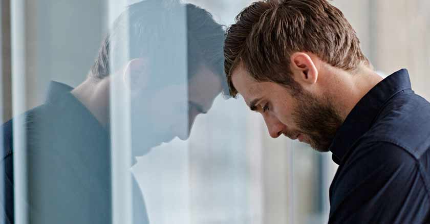 hombre con ansiedad triste recostado sobre vidrio consejos para combatir la ansiedad