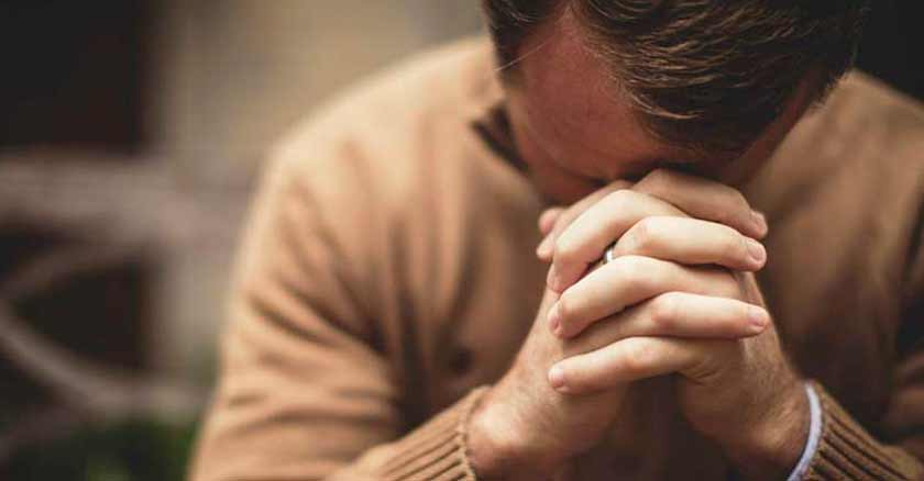 hombre rezando oracion de confianza para enfrentar las pruebas de la vida
