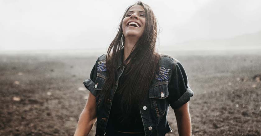 mujer sonriendo muy feliz fondo rocas naturaleza