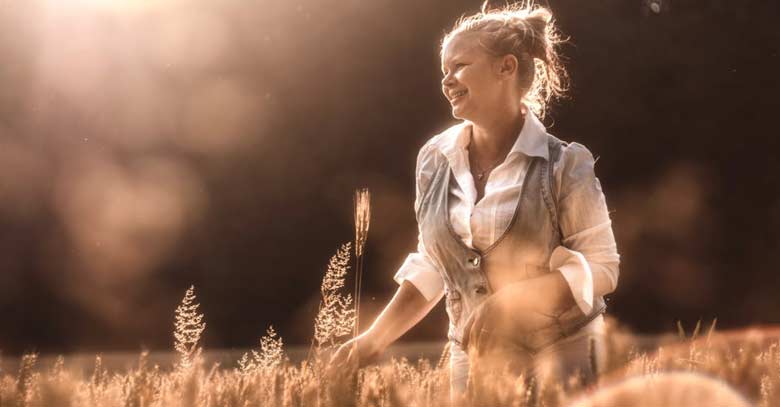 mujer sonriente en el campo flores color sepia 