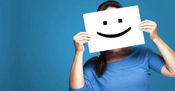 mujer sostiene manos cartel feliz sobre su cara fondo azul 