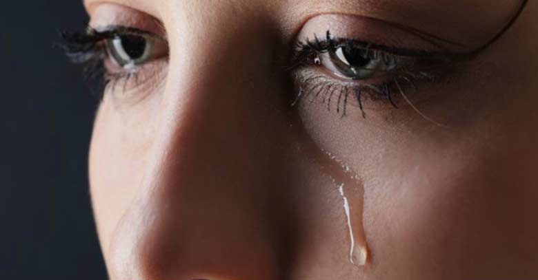 rostro de mujer de cerca llorando lagrimas en mejillas 