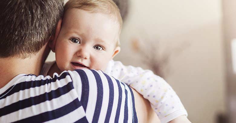 bebe cargado por su papa en la santa misa llora