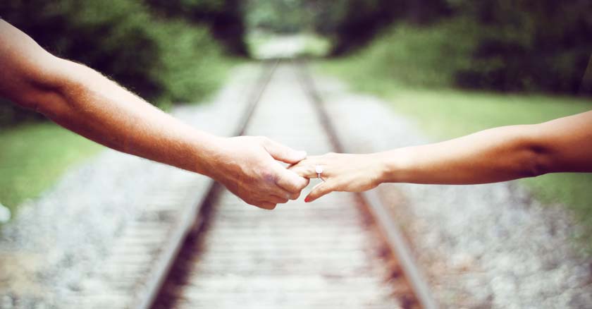 brazos de hombre y mujer juntos vias del tren