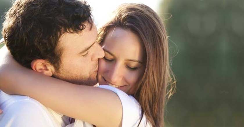 esposo besando a su esposa abrazados sonriendo esposa
