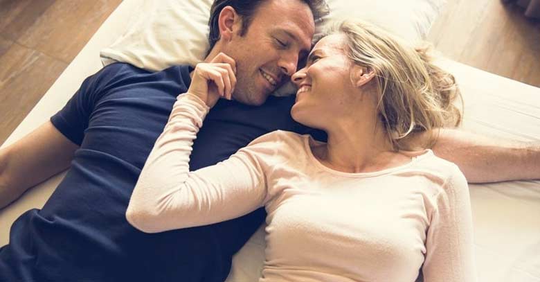 esposos felices recostados en cama matrimonio feliz