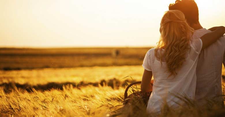 esposos juntos mirando el atardecer en el campo