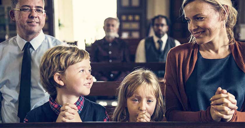 familia catolica reunida en la misa banca rezando papa mama hijos