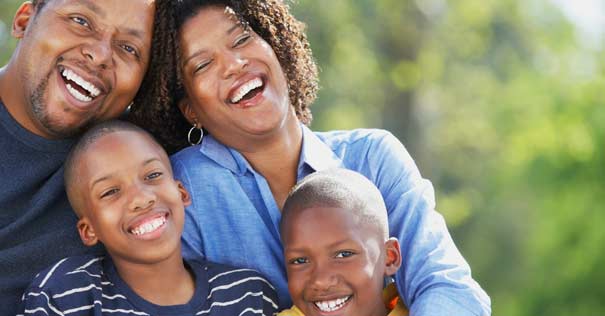 familia unida sonriendo feliz fondo verde arboles 