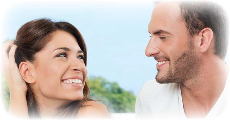 hombre y mujer sonriendo mirandose a la cara 