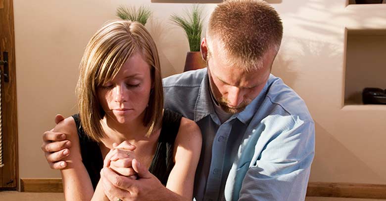 matrimonio pareja esposos rezando oracion juntos de rodillas habitacion