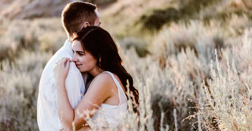 novio abrazando a su novia esposos abrazados fondo pradera