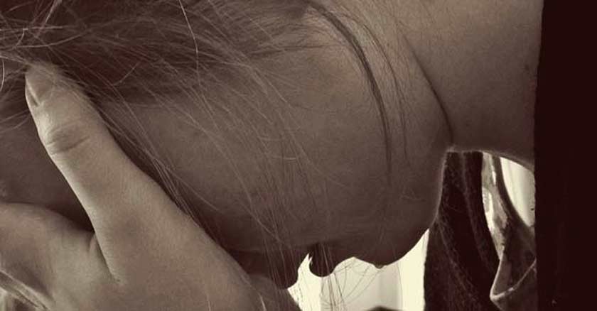 rostro de cerca de mujer tomando su cabeza agotada frustrada triste sepia