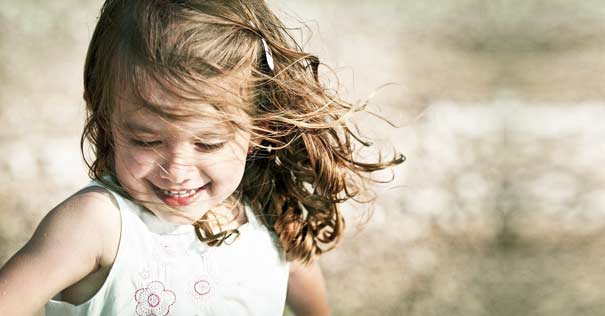 chica nina sonriendo en campo felicidad 