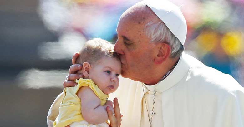 papa francisco besando en la frente a un bebe 