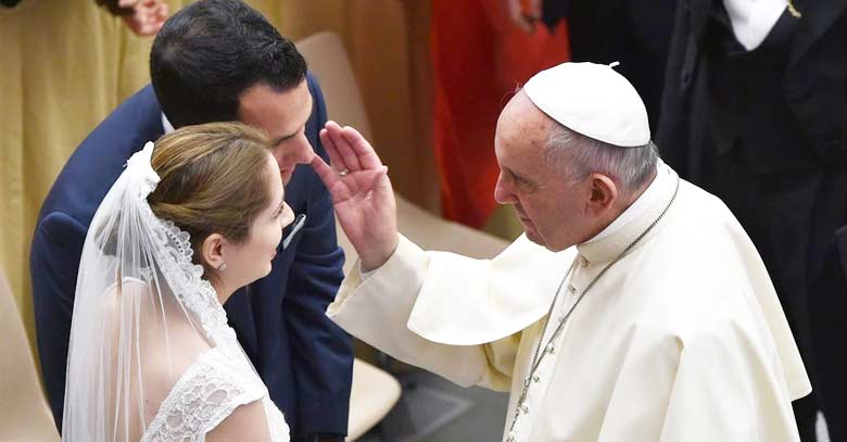 papa francisco conversa con pareja matrimonio bendicion mano levantada