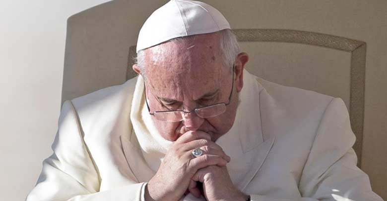 papa francisco manos unidas rezando mirando hacia abajo sentando 