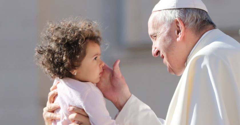 papa francisco mirando y acariciando un bebe nina con ternura