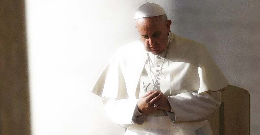 papa francisco rezando con las manos juntas de pie cabeza agachada