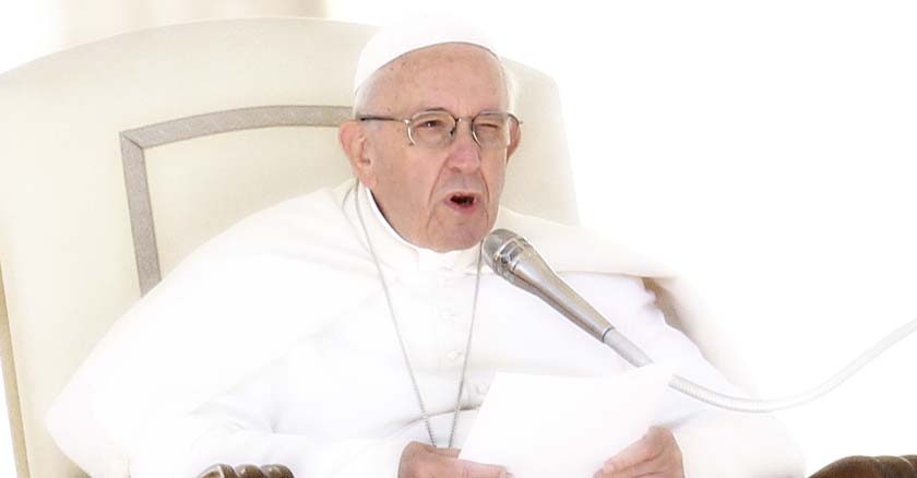 papa francisco sentado en la silla petrina sosteniendo documento en sus manos