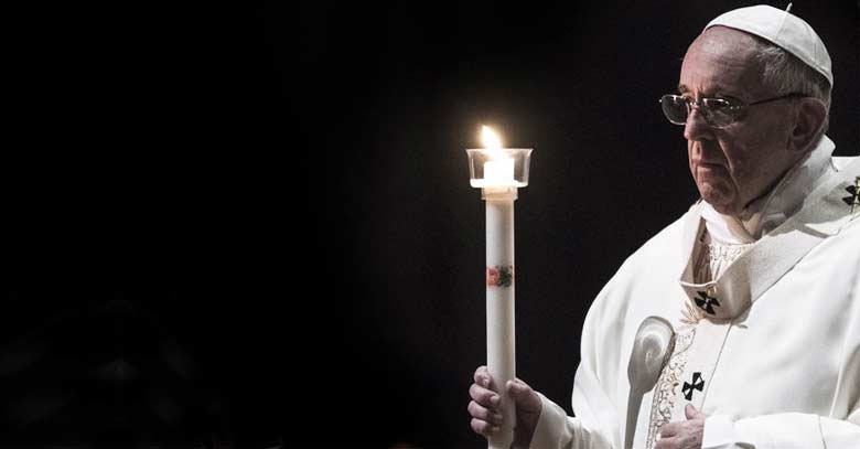 papa francisco sostiene un cirio encenedido fondo negro 