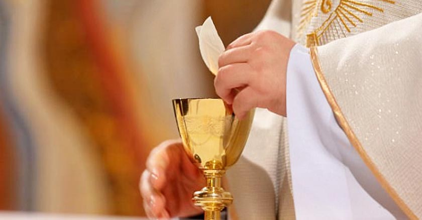 sacerdote consagrando hostia en mano copa devino eucaristia santa misa