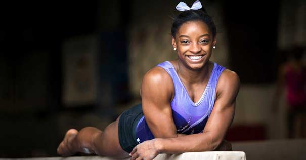 simone biles medallista oro olimpico acostada barra equilibrio