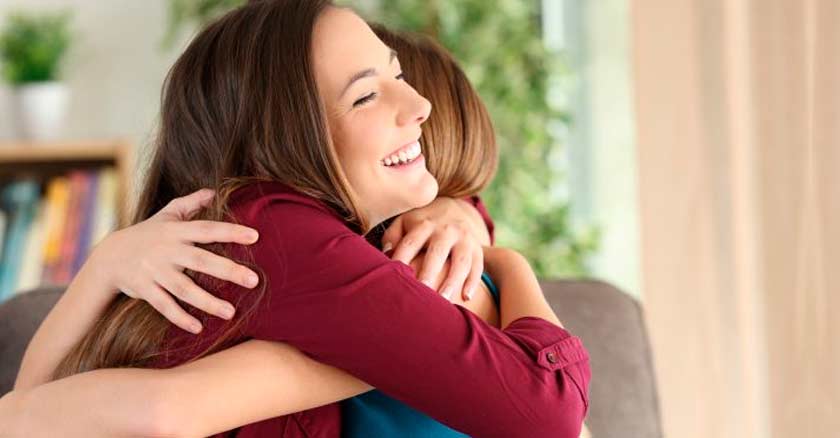 dos mujeres abrazadas sontiendo abrazo de perdon felices