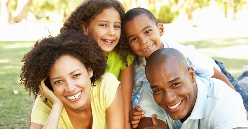 familia juntos felices papa mama hijo e hija sonriendo recostados en el cesped dia 