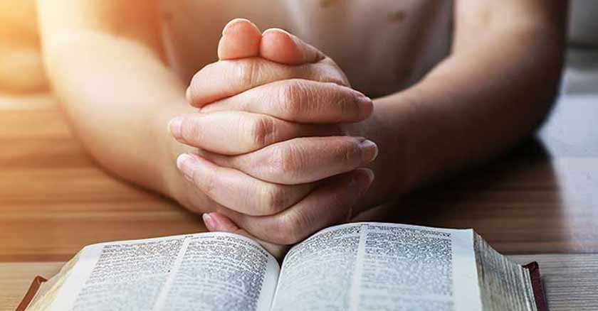 la oracion es el cordon umbilical que nos une a Dios orando manos juntas con Biblia