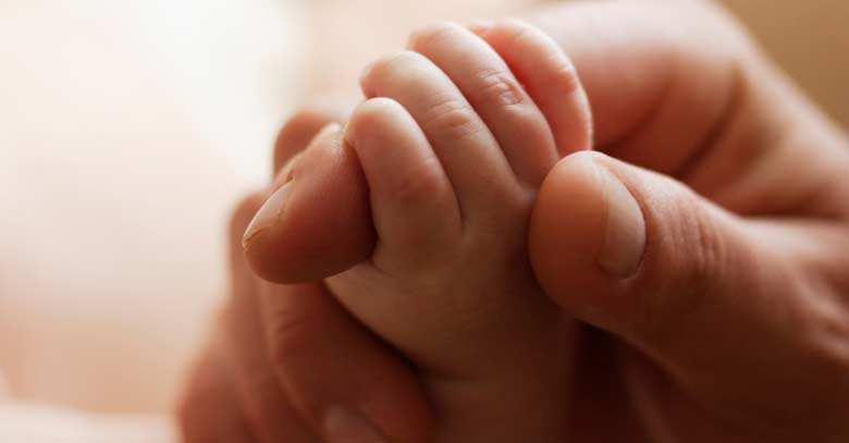 manos de padre tomando la mano de su hijo bebe