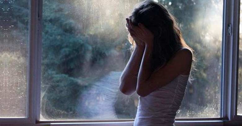 mujer triste llora desconsolada ventana fondo dolor