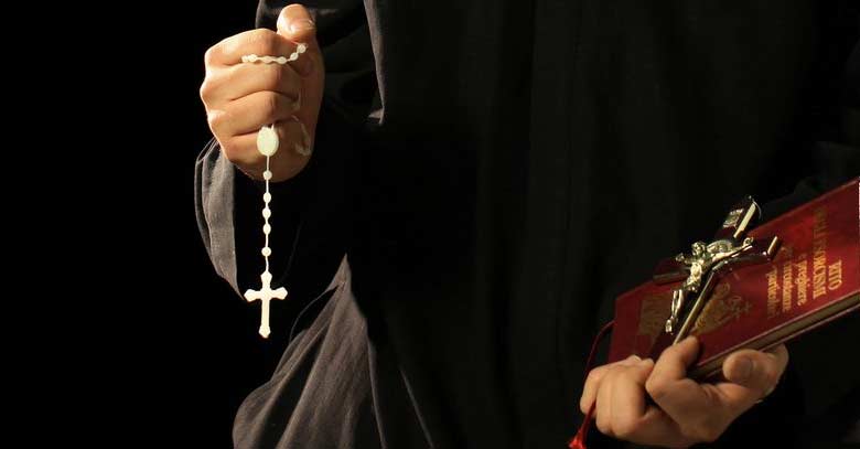 exorcista con cruz rosario en mano y biblia 